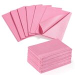 A stack of pink Etercycle disposable nail mats with one unfolded to show its absorbent surface and waterproof backing, ready 